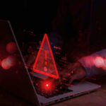 25.9M Americans’ Data Suddenly Exposed Warning symbol over laptop with user.