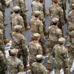 US Troops Land Where? Why? A formation of soldiers in military uniforms marching in a parade