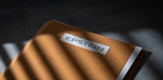 A brown folder with the name 'EPSTEIN' on it, partially illuminated by light and casting shadows