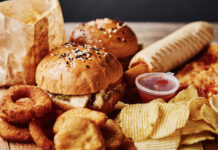 A variety of fast food items including burgers, onion rings, and chips