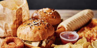 A variety of fast food items including burgers, onion rings, and chips
