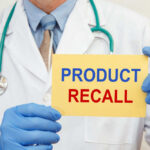 RECALL: Baby Choking Horror Doctor holding a product recall sign in gloves