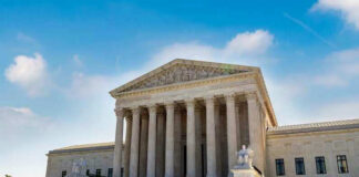 U.S. Supreme Court building exterior under blue sky.