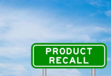 RECALL: Metal Fragment Scare Hits 10 States Green sign with product recall text and sky background
