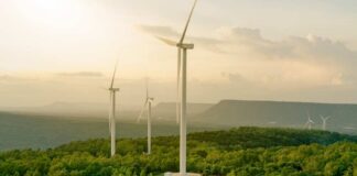 Wind turbines on a hillside during sunset