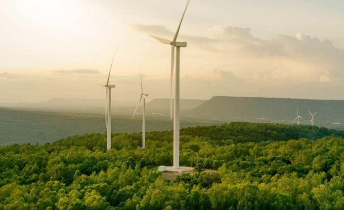 Wind turbines on a hillside during sunset