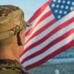 ROTC Cadets’ Heroic Act Honored In Ceremony Soldier in uniform standing in front of an American flag by the ocean