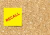 Yellow sticky note with the word 'RECALL' on a corkboard