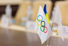 Close-up of Olympic and Ukrainian flags on a conference table
