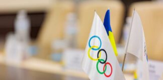 Close-up of Olympic and Ukrainian flags on a conference table