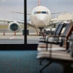 Bin Wars Erupt – Airline Disaster! View of an airplane from an airport waiting area
