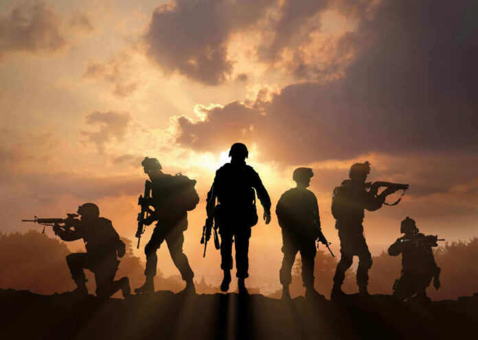 Silhouetted soldiers against a dramatic sunset sky.