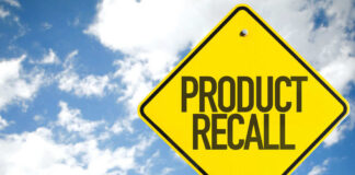 Yellow product recall sign against cloudy sky
