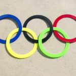 Olympic Gold Queen Bails on Worlds Colorful Olympic rings arranged on sandy surface