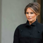 Melania’s Beehive Surprise Revealed Melania Trump in black coat.