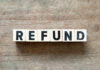 Wooden blocks spelling the word 'REFUND' on a wooden surface
