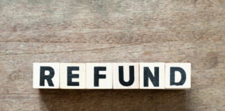 Wooden blocks spelling the word 'REFUND' on a wooden surface