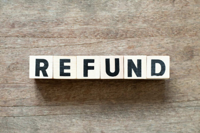 Wooden blocks spelling the word 'REFUND' on a wooden surface