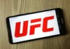 Smartphone displaying the UFC logo on a wooden surface