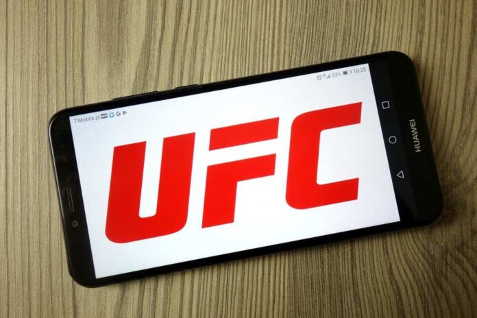 shutterstock_1610483494.jpg Smartphone displaying the UFC logo on a wooden surface