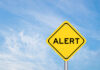 Yellow alert sign against a blue sky