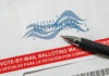 Trump SLAMS Mail-In Fraud — Democrats Racing to Court Vote-by-mail envelope with pen on top.