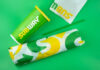 Subway sandwich wrapped in branded paper next to a green beverage cup