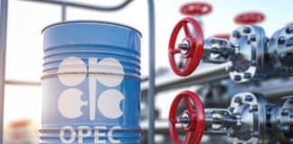 Blue oil barrel with OPEC logo next to industrial valves