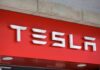 Tesla logo displayed on a red background