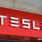 Tesla logo displayed on a red background
