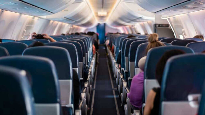 Airplane interior with passengers seated mid-flight.
