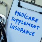 Clipboard with handwritten text about Medicare supplement insurance next to a stethoscope