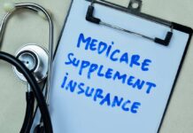 Clipboard with handwritten text about Medicare supplement insurance next to a stethoscope