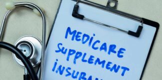 Clipboard with handwritten text about Medicare supplement insurance next to a stethoscope