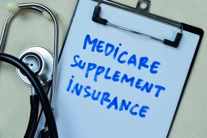 Clipboard with handwritten text about Medicare supplement insurance next to a stethoscope