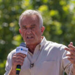 RFK Jr. THREATENS Hospital Funding Over Junk Food Robert F Kennedy, or RFK, speaking outdoors.