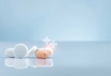 Assorted pills on a reflective surface against a light background