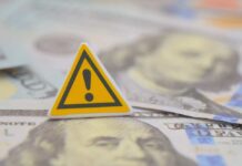 A warning sign placed on top of U.S. dollar bills