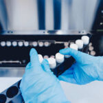 Ebola Outbreak – US Missionary’s Shocking Diagnosis! Person in blue gloves handling test tubes in a laboratory