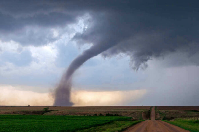 Tornado touching down in an open field area.