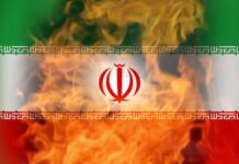 Pentagon’s Iran Strikes – Why Now? Iranian flag with flames in the background