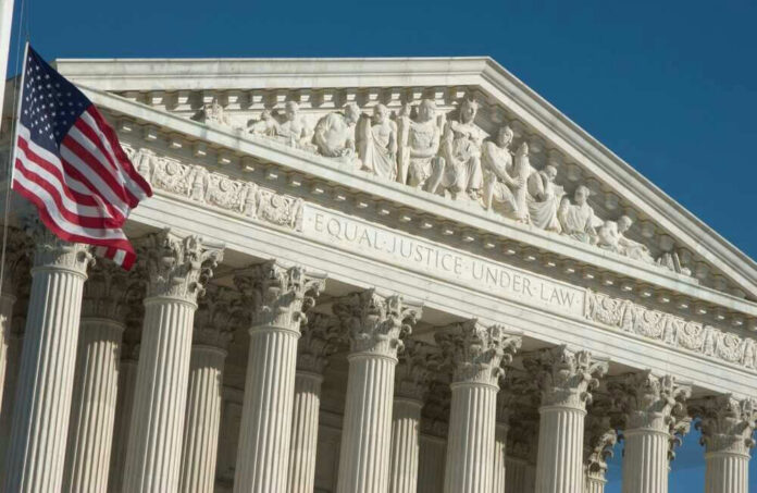 shutterstock_2342942251 U.S. Supreme Court building with American flag.