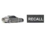 Recall Shocker: Engine Fail Risk! A miniature gray sports car next to a black sign that reads 'RECALL'