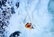 Experienced Climber DIES Hours After Summit Victory A climber ascending a frozen ice wall in a snowy landscape
