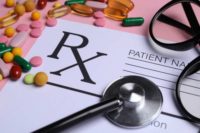 Medical,Prescription,Form,,Pills,,Glasses,And,Stethoscope,On,Pink,Background, Prescription pad with various colorful pills and a stethoscope