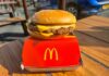 McDonald’s Ending THIS Freebie A cheeseburger from McDonald's placed on a red box on a wooden table