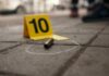 VIDEO: Carjacker SHOT Dead; Dad Protects Family Bullet casing on the ground next to a numbered evidence marker