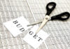 Budget Chaos FREEZES Army Training Scissors cutting a paper labeled 'BUDGET' on a financial spreadsheet