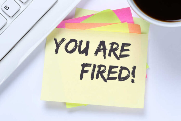 shutterstock_543915679.jpg A sticky note with the message 'YOU ARE FIRED' placed on a desk next to a keyboard and a cup of coffee