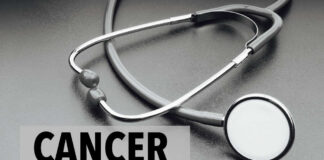 A stethoscope on a dark surface with the word 'CANCER' prominently displayed